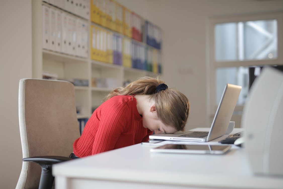  a tired employee sitting at her desks